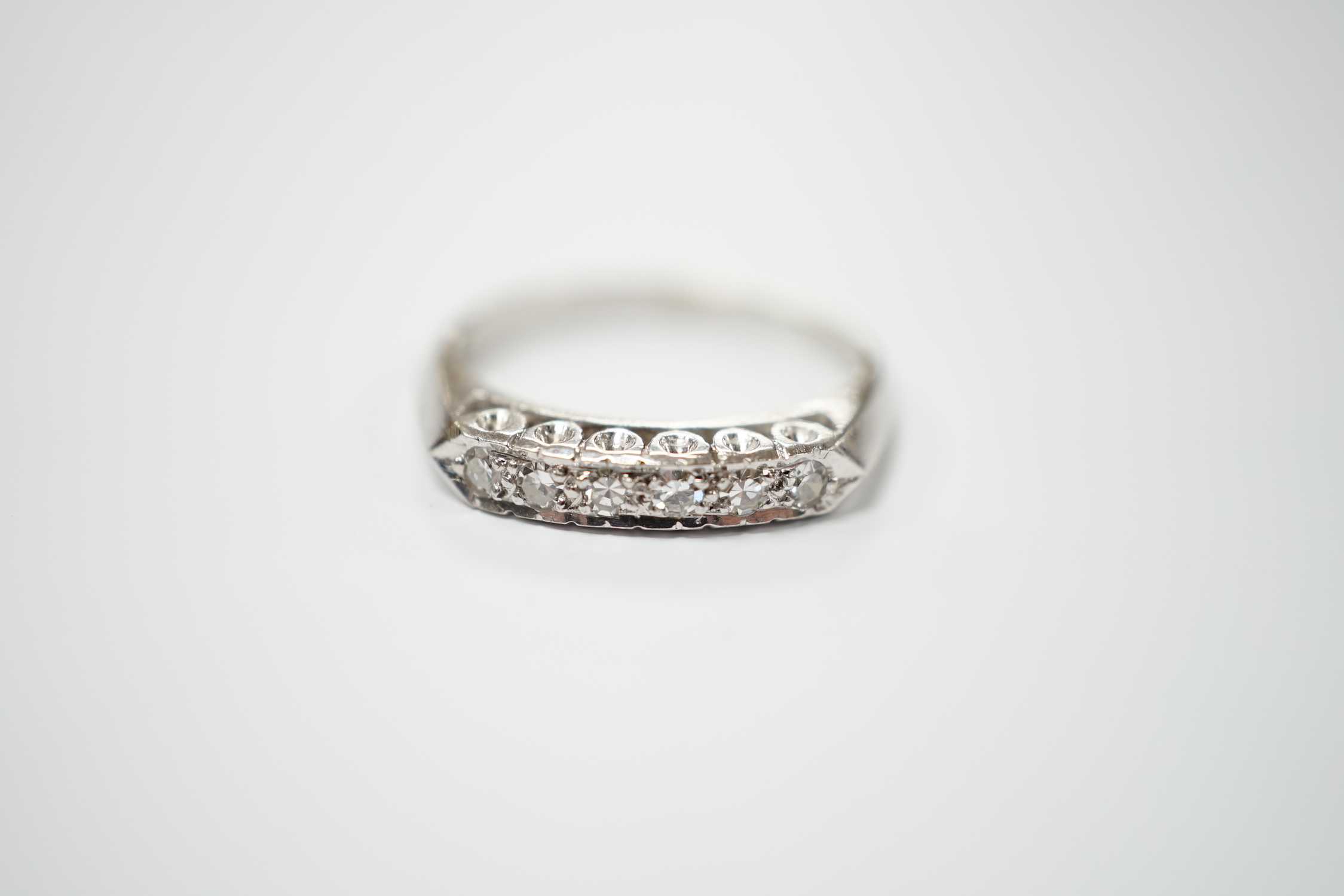 A 14k white metal and six stone diamond chip set half hoop ring, size L, gross weight 2.6 grams.